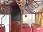 車廂內景：紅色仿皮面座椅、木紋扶手、金色鈴鐺