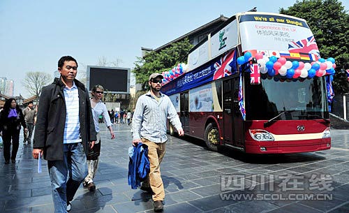 在寬窄巷子，幾位外國游客從世博大巴旁經(jīng)過
